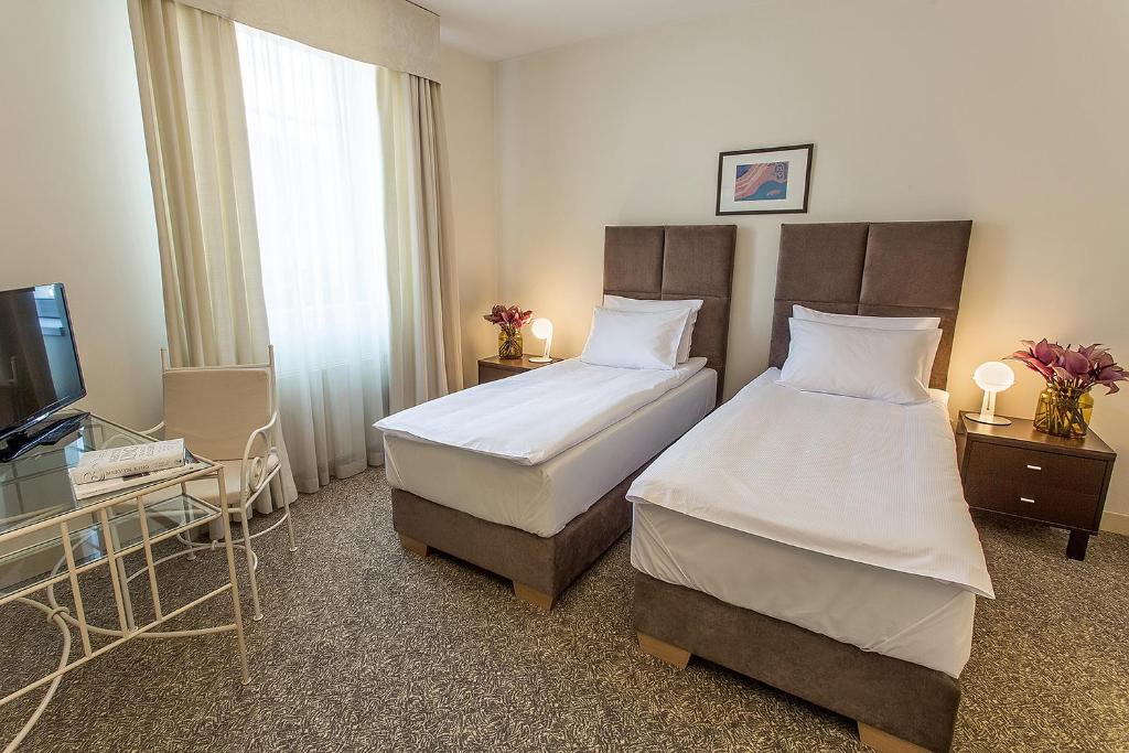 Postel nebo postele na pokoji v ubytování Mamaison Residence Izabella Budapest