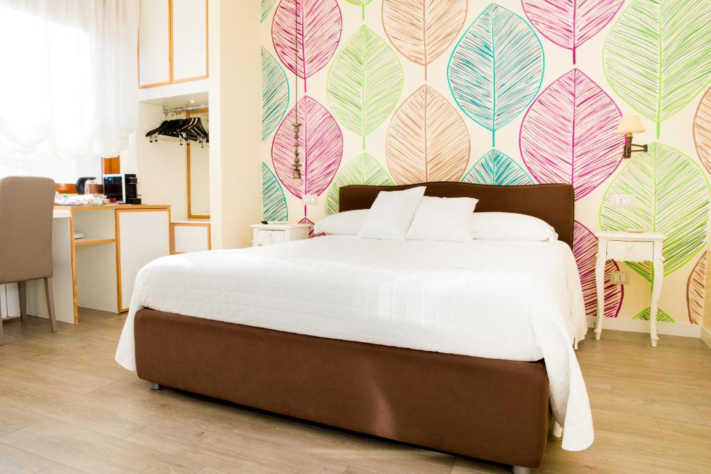 um quarto com uma cama grande e papel de parede floral em Il Castello em Tivoli