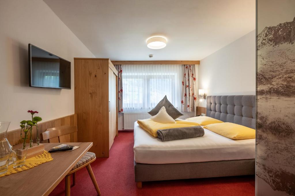 une chambre d'hôtel avec un lit et une table dans l'établissement Hotel Garberwirt, à Hippach