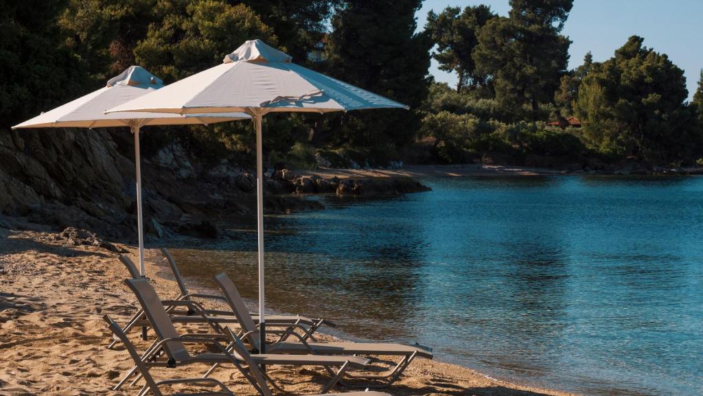 two chairs and an umbrella on a beach at Casa Bloo Adults Only in Elia