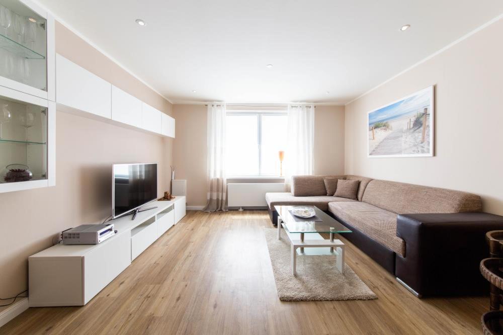 a living room with a couch and a tv at Ferienwohnung 1 Haus Meeresrauschen in Haffkrug