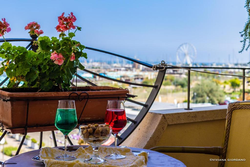due bicchieri da vino seduti su un tavolo con vista di Hotel River fronte mare con piscina a Rimini