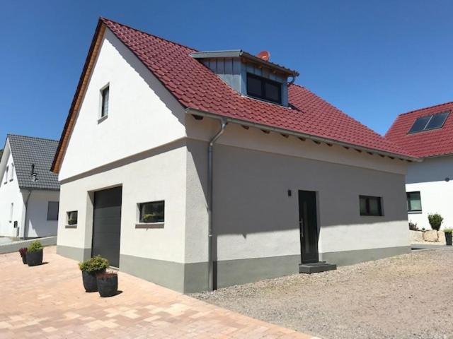 une grande maison blanche avec un toit rouge dans l'établissement FeWo Stubenhocker, à Pleisweiler-Oberhofen