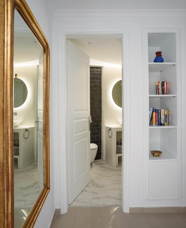 a bathroom with a mirror and a toilet at Villa Renos Hotel in Fira