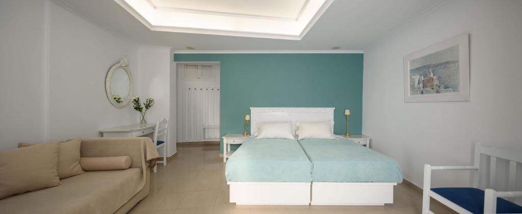 a living room with a bed and a couch at Villa Renos Hotel in Fira