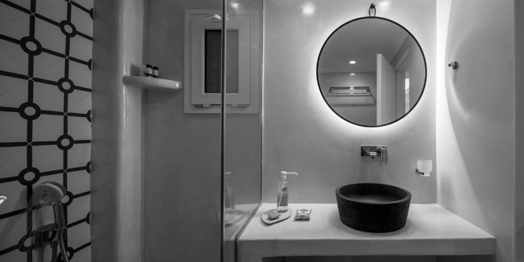 a bathroom with a shower and a sink with a mirror at Villa Renos Hotel in Fira