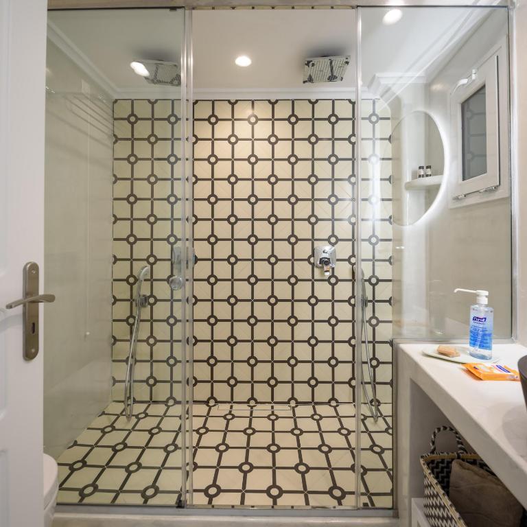 a bathroom with a shower with a glass door at Villa Renos Hotel in Fira