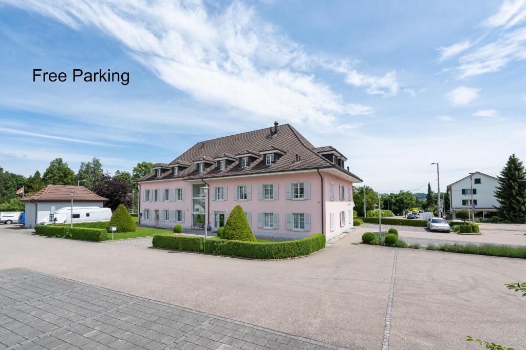 ein großes weißes Haus mit grauem Dach in der Unterkunft Bären Self Check-in Hotel in Solothurn