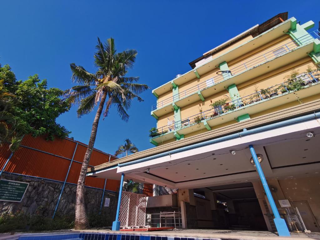 una palmera frente a un edificio en Metro Park Hotel - Cebu City, en Cebú