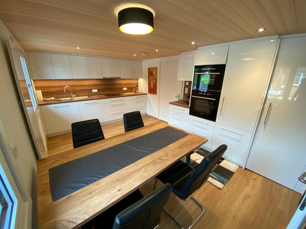 a kitchen with a large wooden table and chairs at Haus Raid in Krumbach