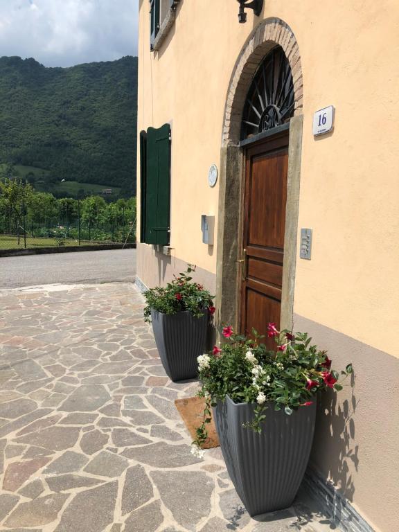 Deux pots de fleurs sur le côté d'un bâtiment avec une porte dans l'établissement Da Rita, à Crone