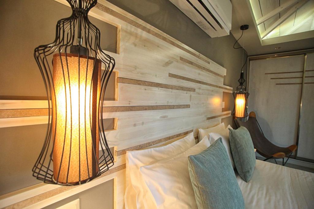 a room with a bed and a chandelier at Nostos Hotel in Afitos