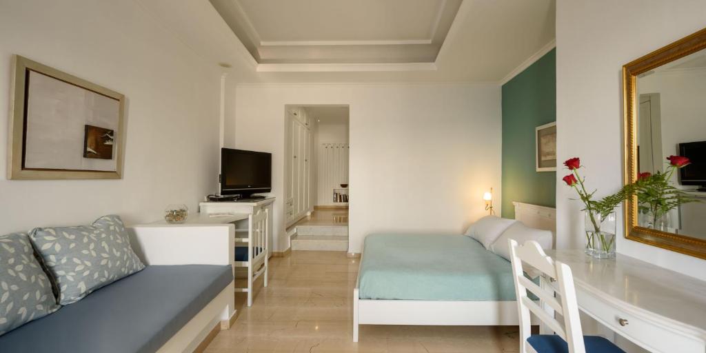 a living room with a couch and a dining room at Villa Renos Hotel in Fira