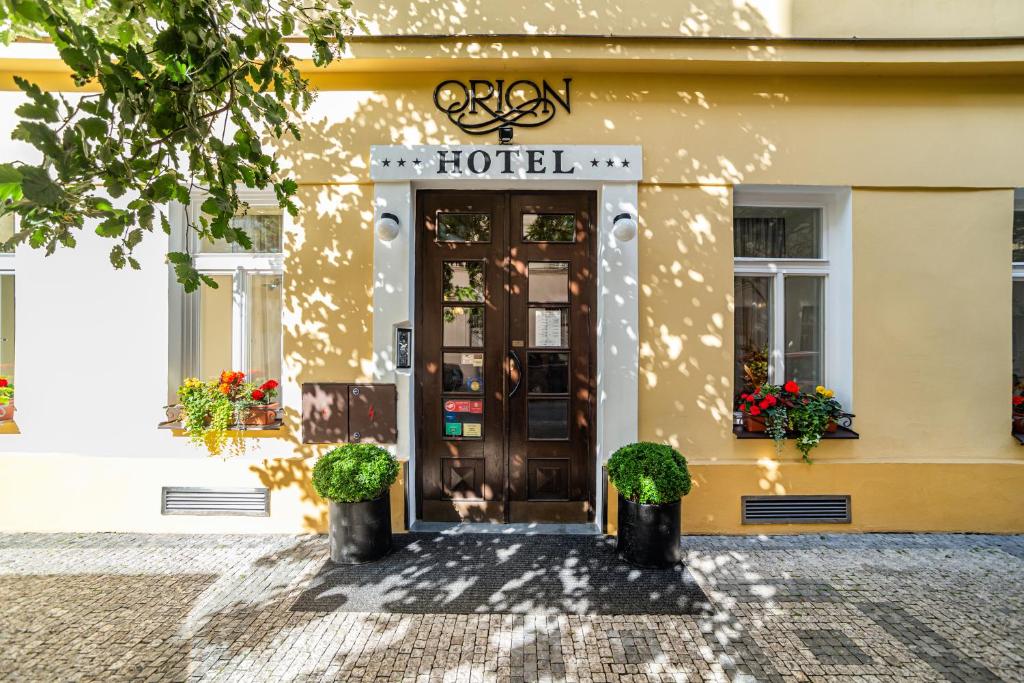 eine Hoteltür mit Pflanzen davor in der Unterkunft Hotel Orion in Prag