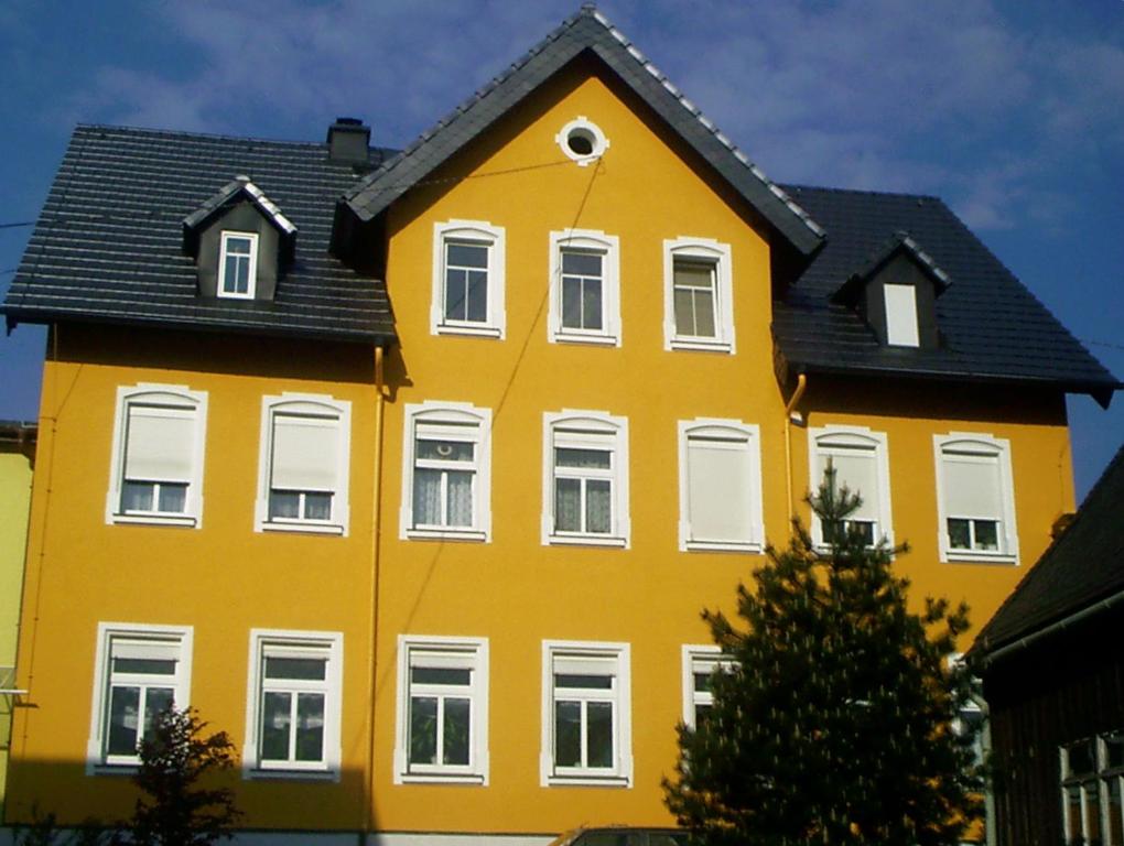 a yellow house with a black roof at Urlaubsdomizil Lengefeld in Lengefeld