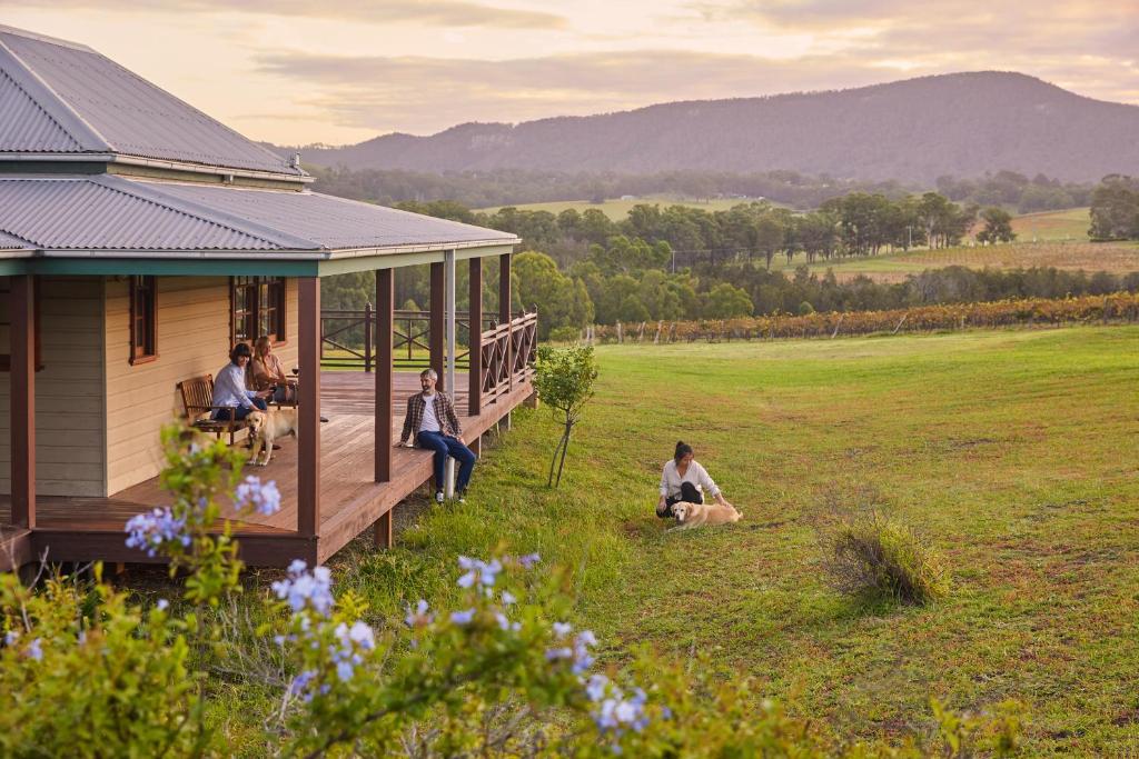 a group of people sitting on a porch of a house at Hanging Tree Wines in Pokolbin