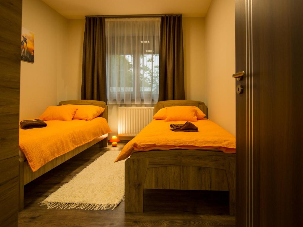 a bedroom with two beds and a window at Bodzaház Apartman in Tarján