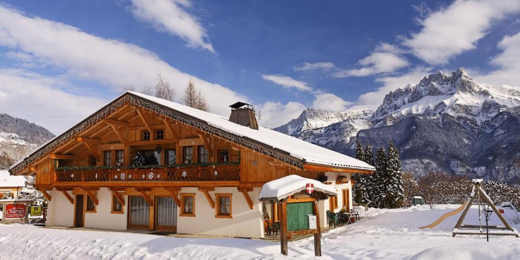 uma casa na neve com montanhas ao fundo em Le Charvet em Cordon