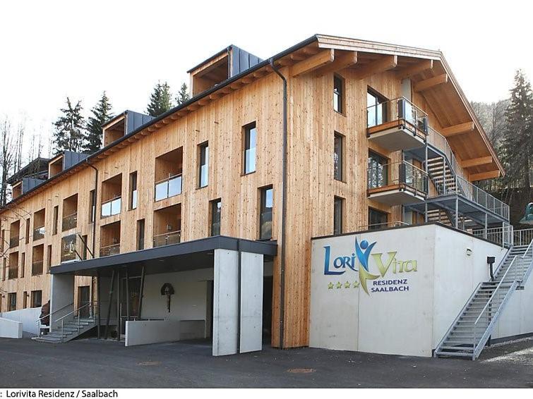 a large brick building with a staircase in front of it at LoriVita Residenz Saalbach in Saalbach-Hinterglemm