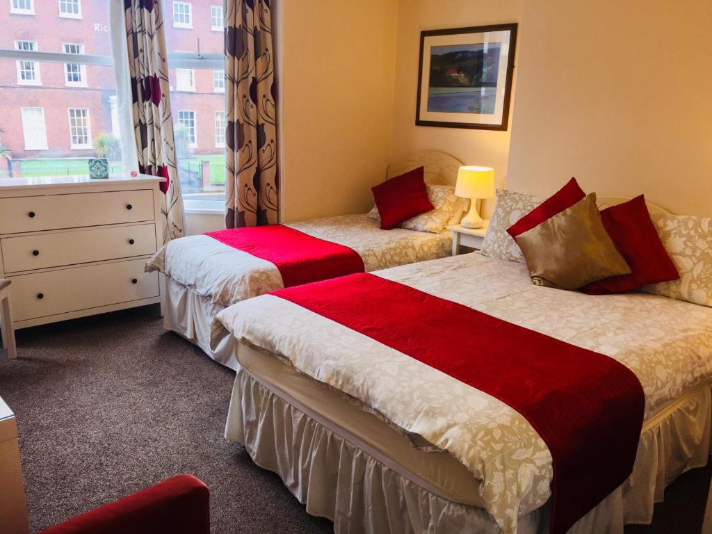 a hotel room with two beds and a window at Shrubbery Guest House in Worcester