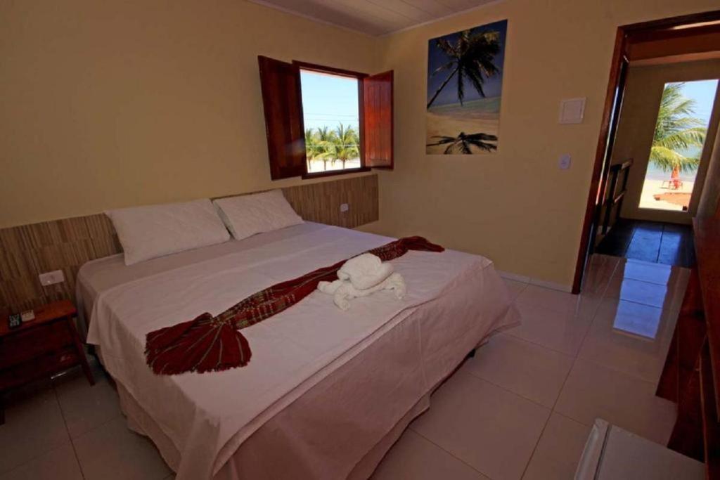 a bedroom with a bed with a towel on it at Pousada Mama Pereira in Japaratinga