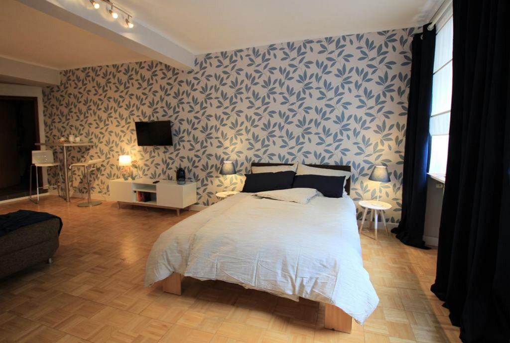 a bedroom with a bed with a blue and white wallpaper at FerienNest Bad Ems, Appartment RankenNest in Bad Ems