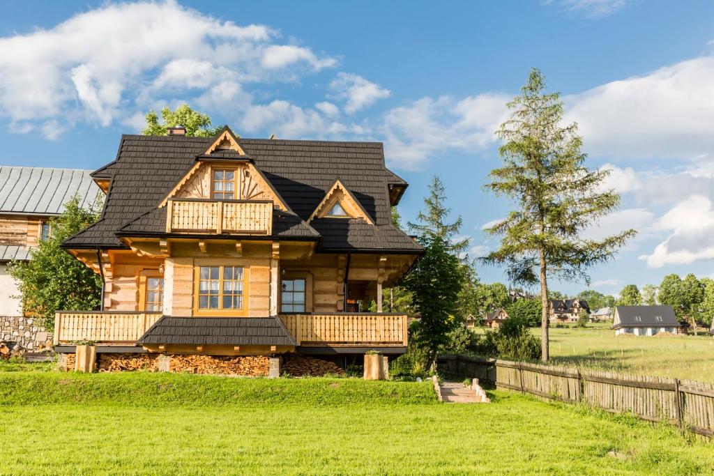 ein Blockhaus mit einem schwarzen Dach in der Unterkunft udanypobyt Liliowa Chata in Kościelisko