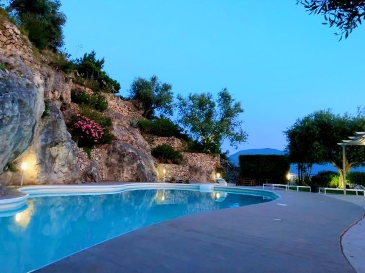 a swimming pool in front of a rock wall at Il Saretto in Sarno