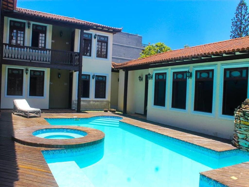 a swimming pool in the backyard of a house at OYO Hotel La Dolce Vita, Rio das Ostras in Rio das Ostras