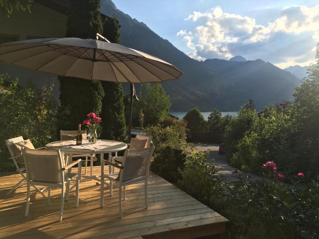 a table and chairs with an umbrella on a deck at Ferienwohnung Lentner in Maurach