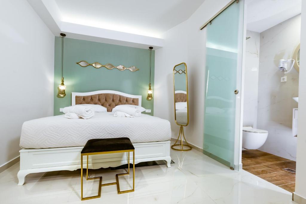 una camera con un letto bianco e una parete di vetro di Konmari Boutique Suites a Chania