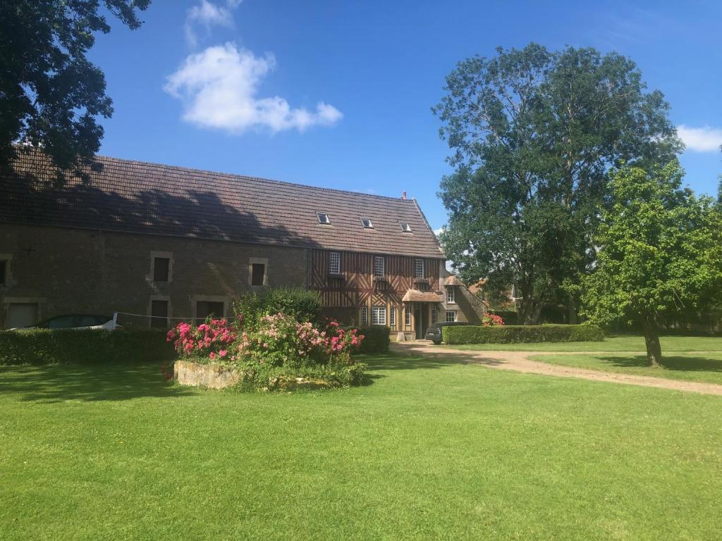 une maison avec une cour verdoyante et un arbre dans l'établissement Gîte de charme à la campagne, à Troarn