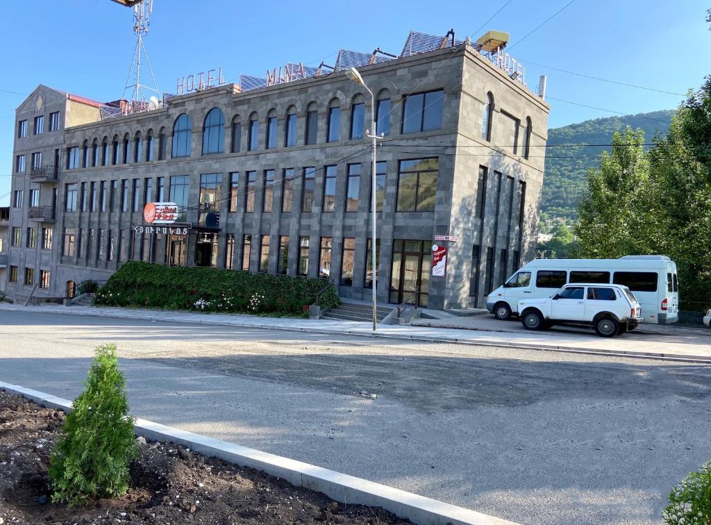 a white van parked in front of a building at Mina Hotel in Goris