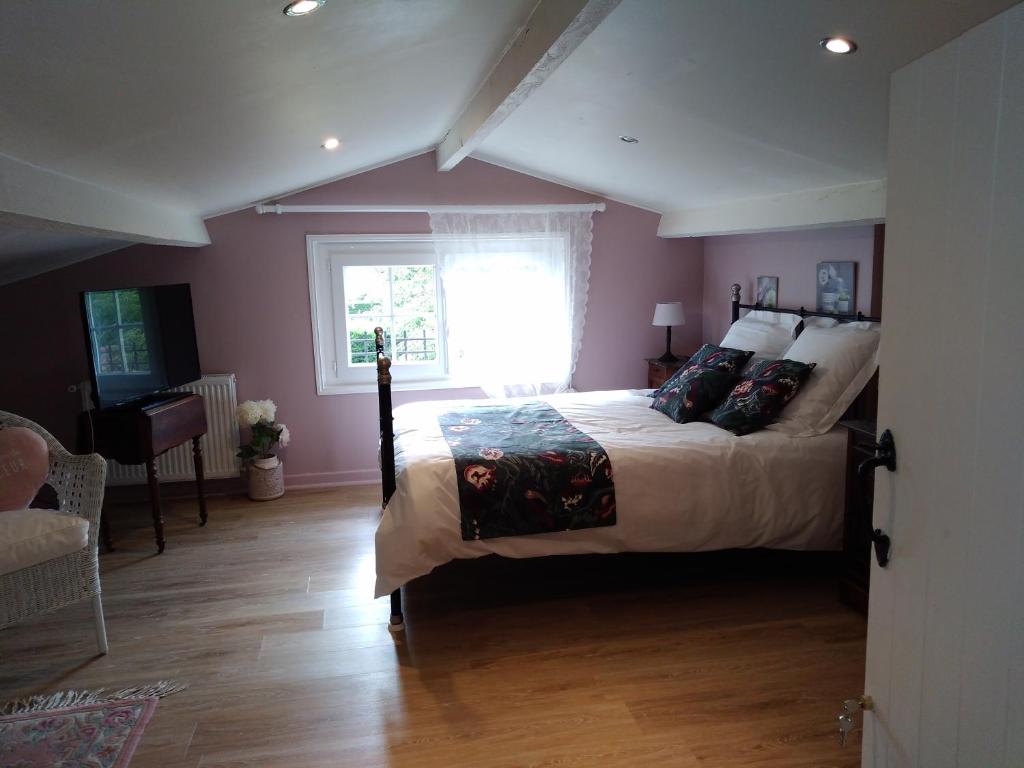 a bedroom with a large bed and a window at Au Cœur de Ménestérol Chambre Émotion in Montpon-Ménestérol