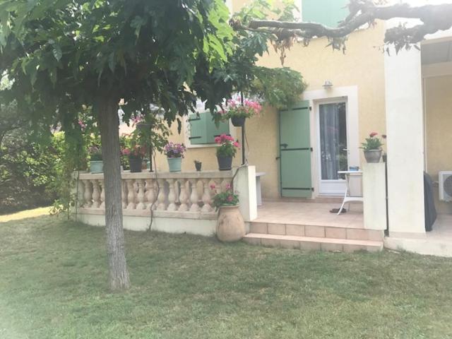 une maison avec une clôture et un arbre dans la cour dans l'établissement LE CARABIOL - Chambre d'Hôte, à Saint Julien Les Rosiers
