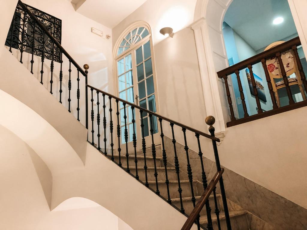 Una escalera en una casa con ventana en Apodaca Rooms en Cádiz