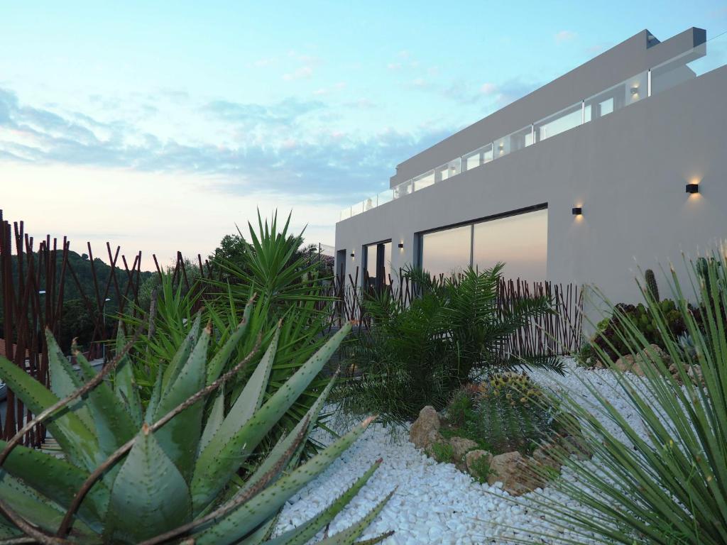 una casa con muchas plantas delante de ella en Casa Lou, architect villa with heated pool at Begur, 470m2, en Begur