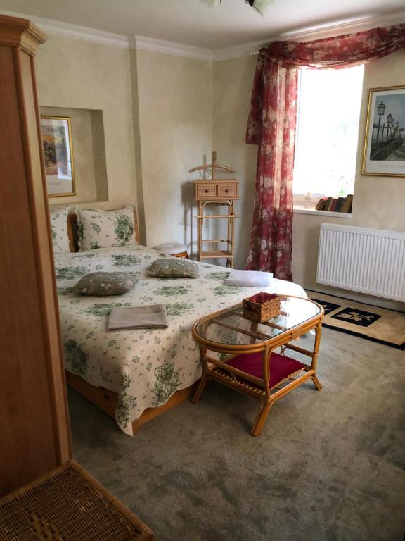 Schlafzimmer mit einem Bett, einem Tisch und einem Fenster in der Unterkunft Vila Kost in Sobotka