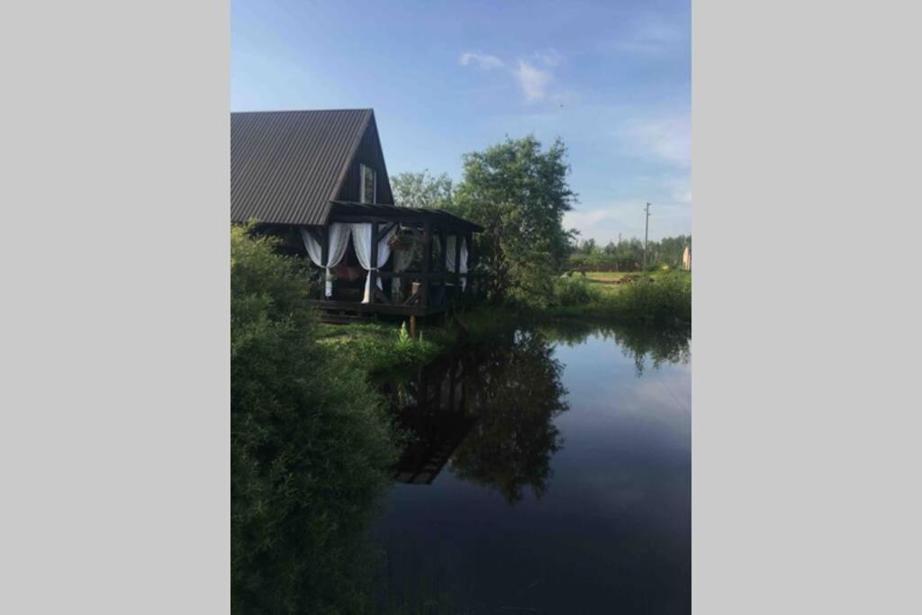 une maison sur une rivière avec réflexion dans l'eau dans l'établissement Stay at hosts, à Rēzekne