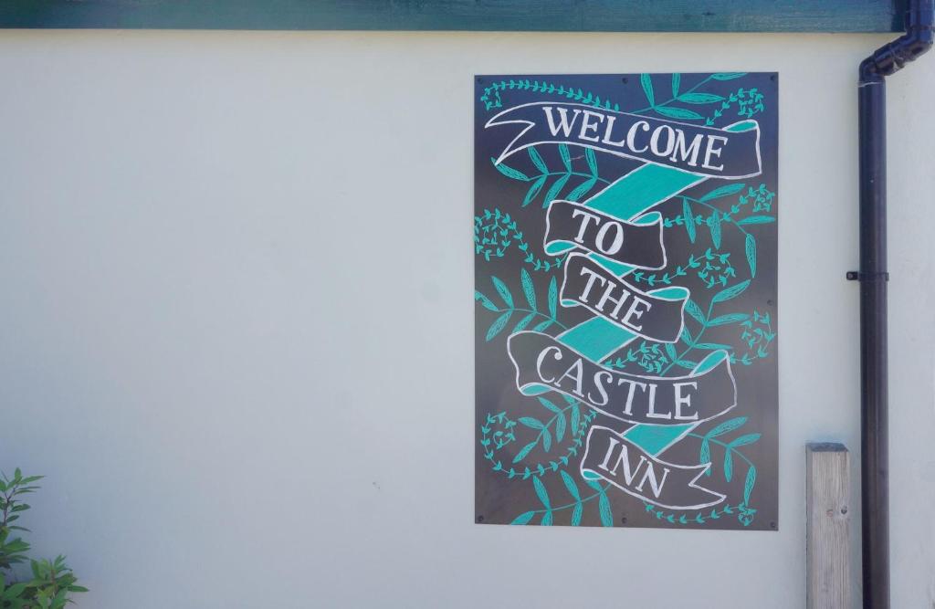 una bienvenida al cartel de la posada del castillo en una pared en Castle Inn, en Newport