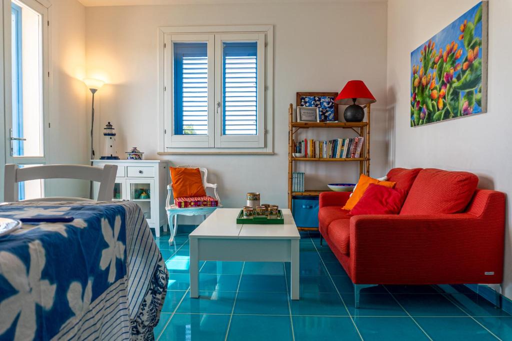 ファヴィニャーナにあるTra Vento e Mareのリビングルーム(赤いソファ、テーブル付)