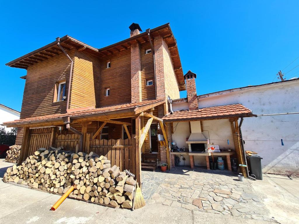 Uma casa com uma pilha de troncos à frente. em Villa Mura em Razlog