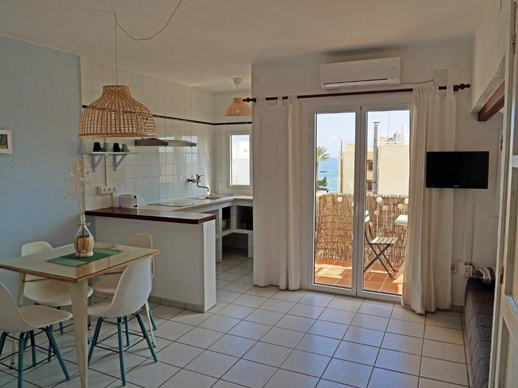 eine Küche und ein Esszimmer mit einem Tisch und Blick auf einen Innenhof in der Unterkunft Bonito apartamento a 20m del mar in Es Pujols