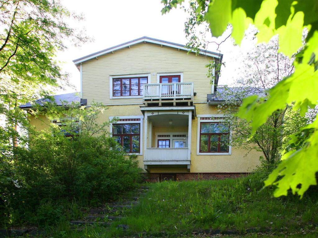 uma casa amarela com um alpendre e uma varanda em Wivi`s em Jyväskylä