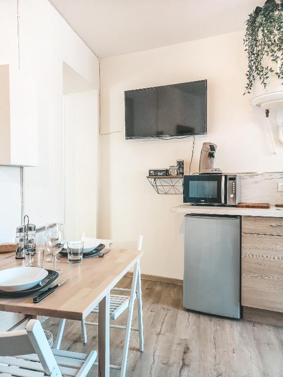 a kitchen with a wooden table and a microwave at La Loggia - Appartement Terrasse + Garage à Grenoble in Grenoble