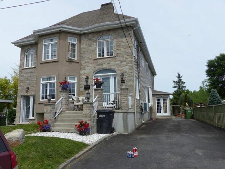 een groot bakstenen huis met een veranda en een oprit bij Chez Danny in Montreal