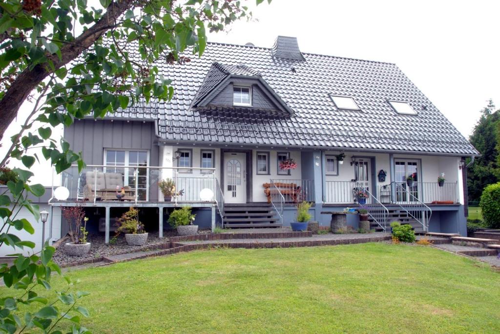Biały dom z werandą i dziedzińcem w obiekcie Ferienwohnung Pfeil w mieście Blankenheim