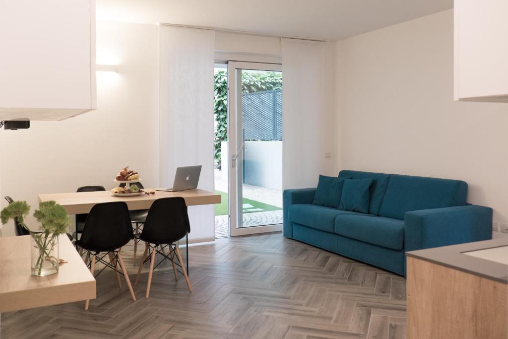 ein Wohnzimmer mit einem blauen Sofa und einem Tisch in der Unterkunft Terrazze dei Tigli in Riva del Garda