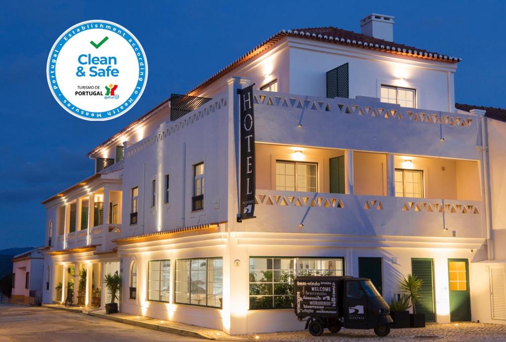 a white building with a sign that says clean and safe at Hotel Alcatruz in Aljezur