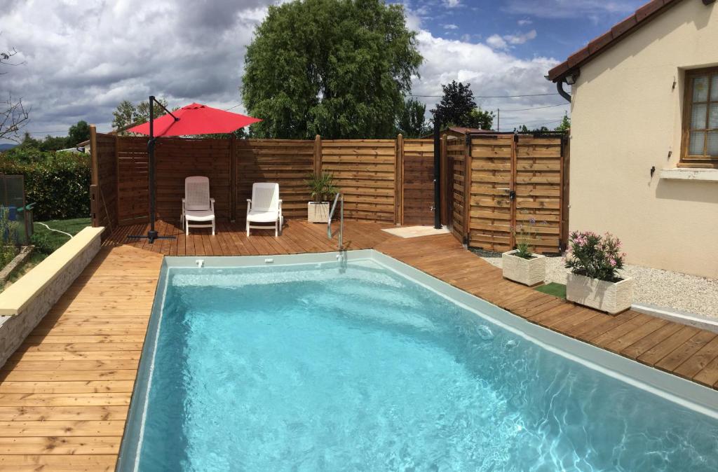 a swimming pool in a backyard with a wooden fence at Gite de Belle vue in Semur-en-Brionnais